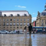 tourists enjoying place de la bourse water mirror