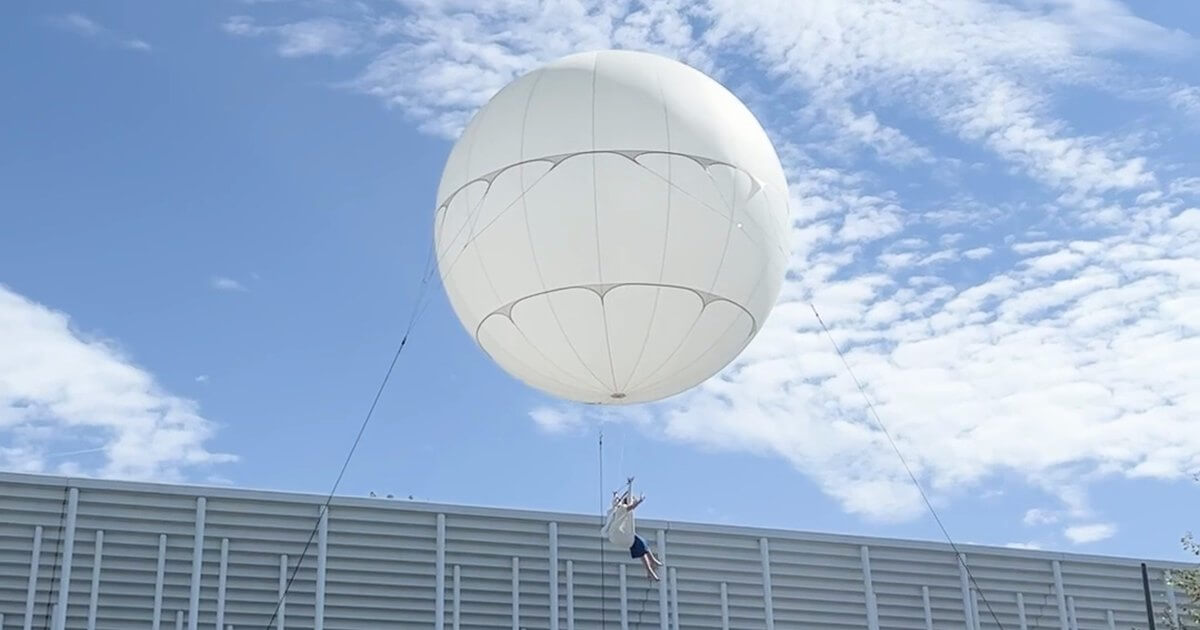 Artiste suspendue sous un ballon géant blanc, spectacle aérien du FAB, festival des arts de Bordeaux Métropole