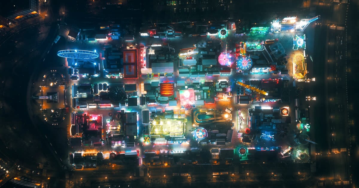 La Foire aux Plaisirs illuminée de nuit sur la place des Quinconces, vue aérienne en drone
