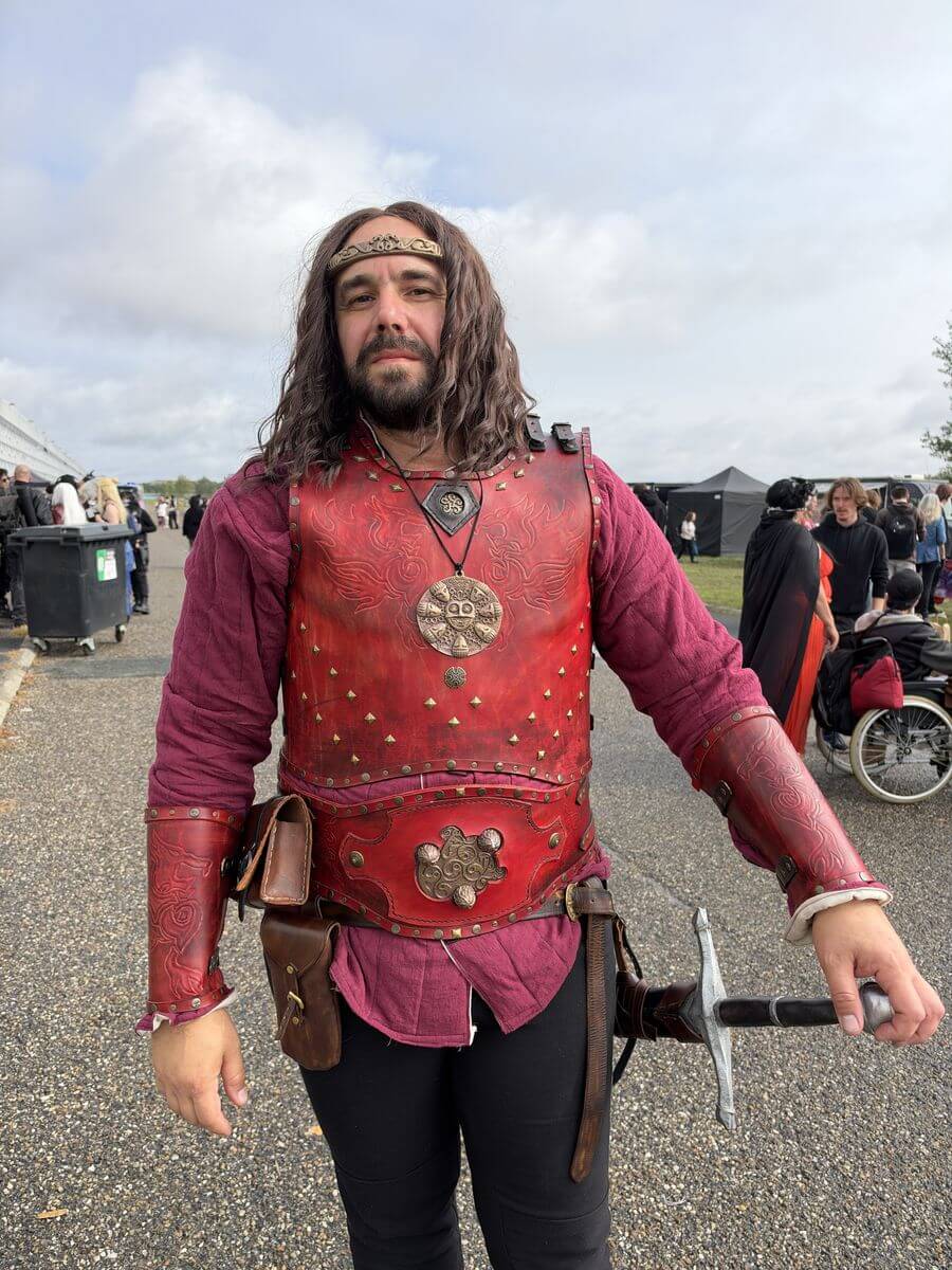 Cosplayeur en chevalier en armure de cuir rouge avec une épée à Animasia 2026