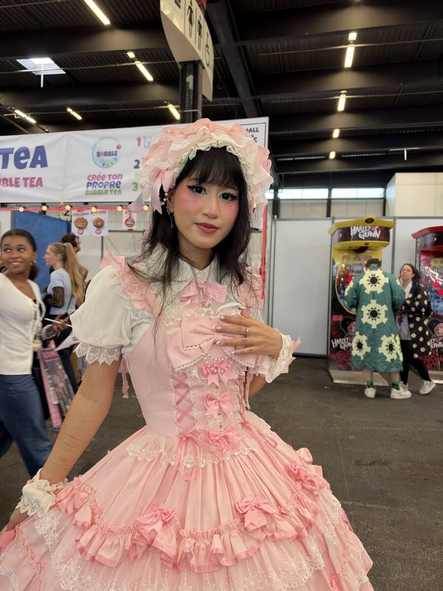 Cosplayeuse en robe Lolita rose à froufrous dans les allées d'Animasia 2026