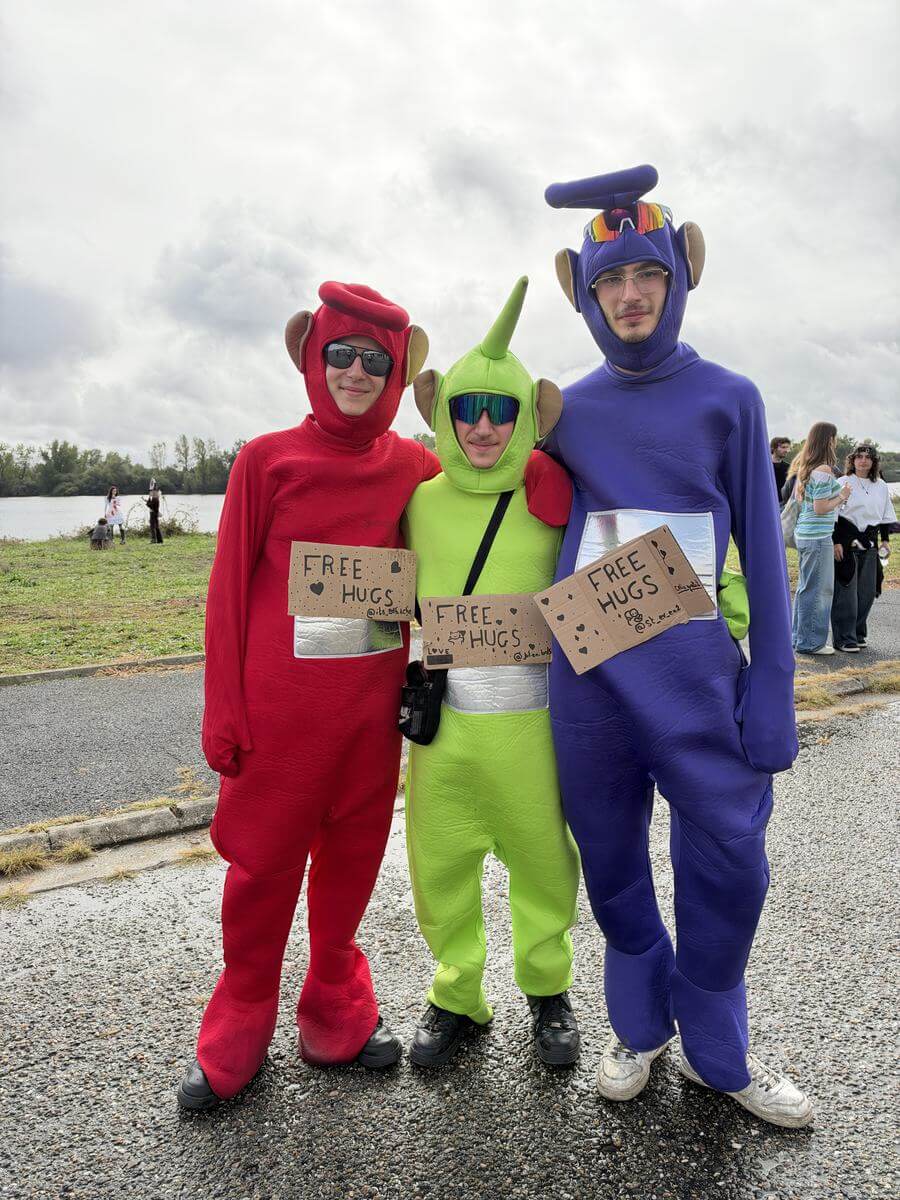 Trois cosplayeurs déguisés en Télétubbies avec des pancartes Free Hugs à Animasia Bordeaux
