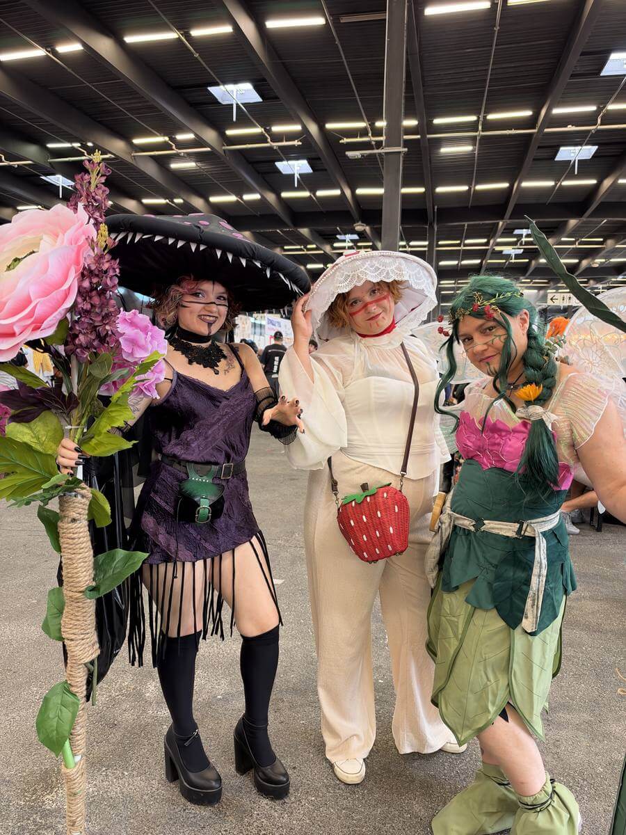 Trois cosplayeuses avec des costumes fleuris et des chapeaux à Animasia Bordeaux