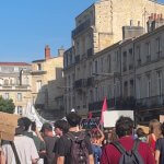 Cortège de la mobilisation lycéenne dans le centre de Bordeaux, manifestants de dos avec pancartes