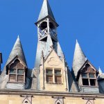 Les tourelles et le clocheton de la porte Cailhau sous un ciel bleu à Bordeaux
